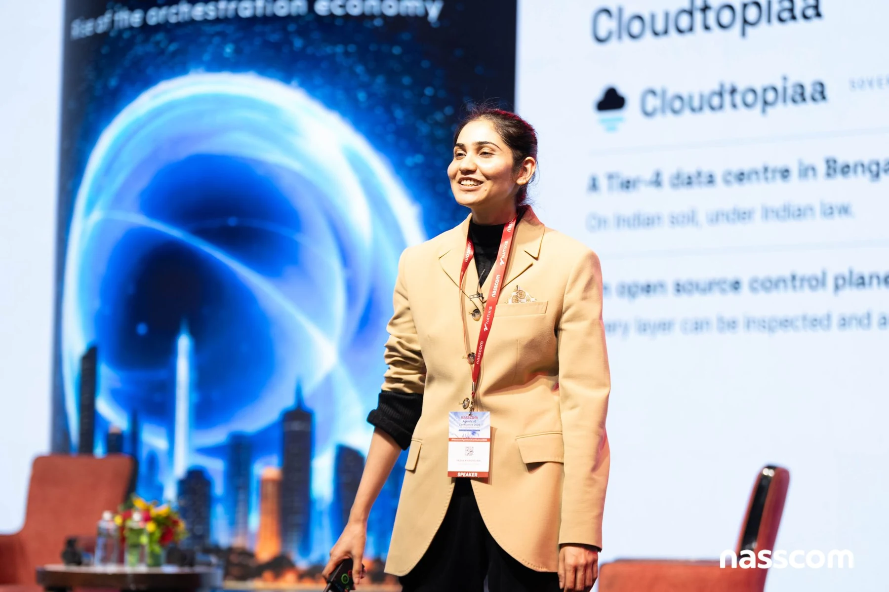 Yasha Khandelwal on stage at the Nasscom Agentic AI Confluence, with a Cloudtopiaa slide behind her reading A Tier-4 data centre in Bengaluru